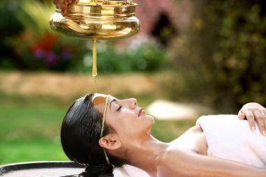 woman laying on a table with oil on her head