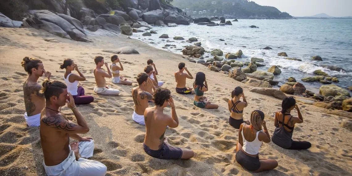 people doing breathing exercises on the beach