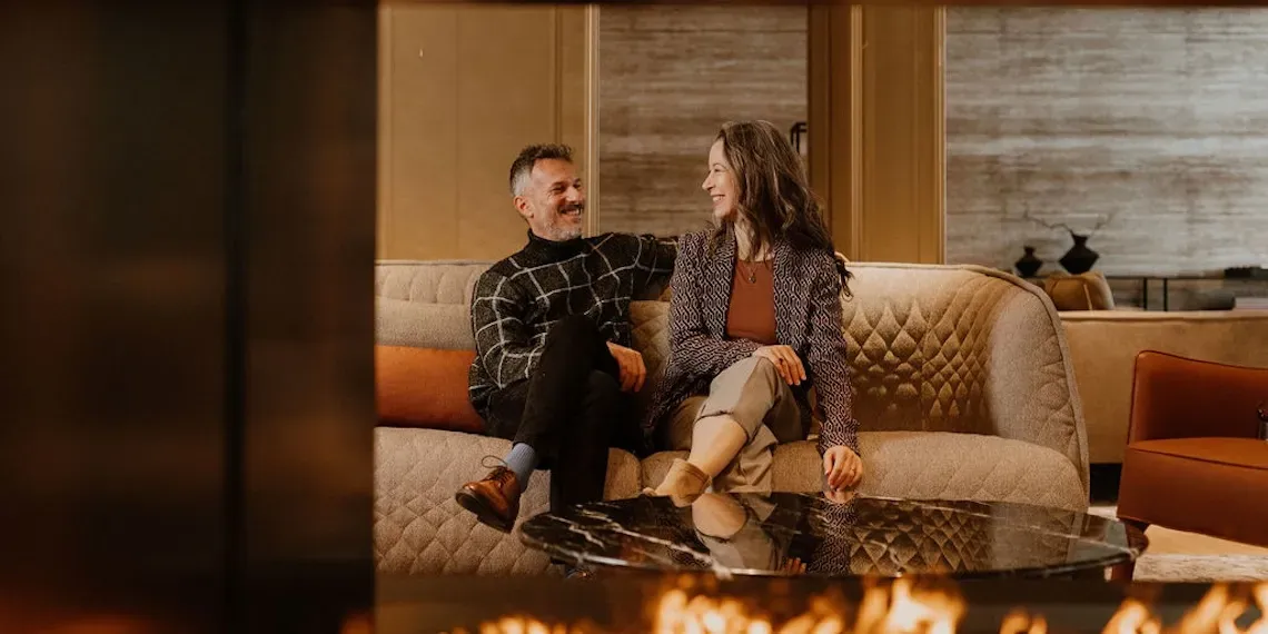two people sitting in a lounge smiling