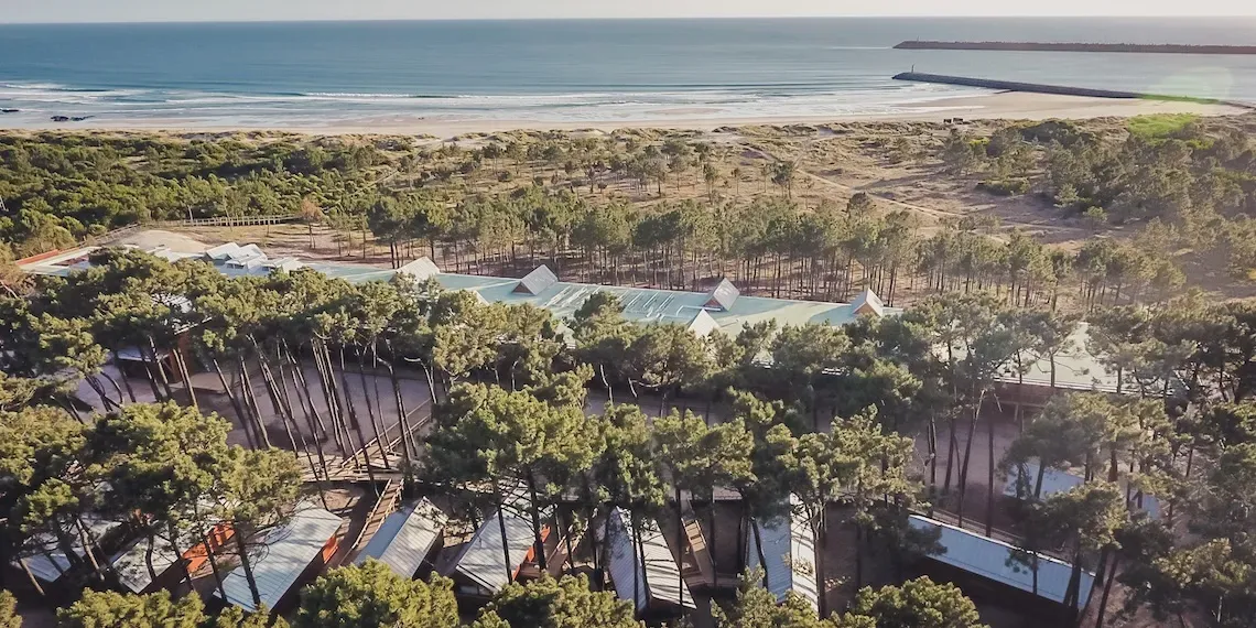 view of hotel, trees beach and ocean