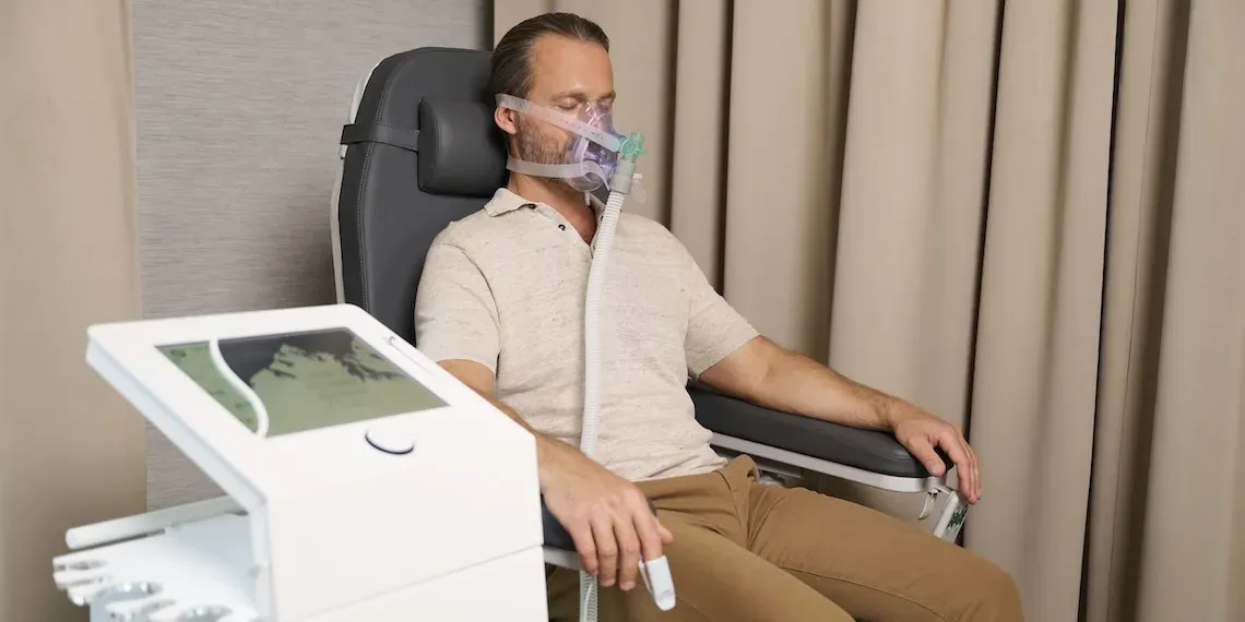 man receiving a medical treatment with a mask on his face