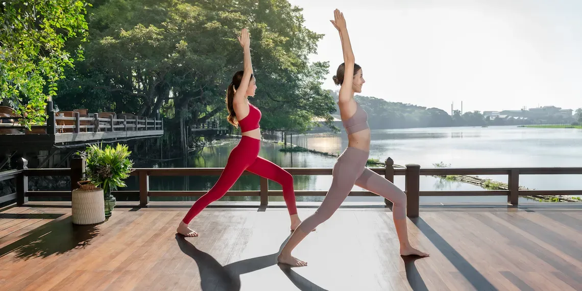 two women doing yoga at the river