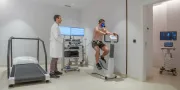 cardiology unit with man on a bike machine with sensors on his body and an oxygen mask with a doctor supervising