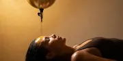 woman on treatment table with warm oil on her forehead Shirodhara