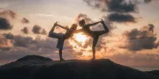 two people doing yoga on the rocks