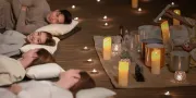 four people getting crystal therapy with candles