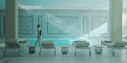 woman walking in a white spa in front of a pool and lounge beds