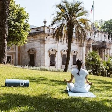 lady sitting in yoga pose in front of old Italian building