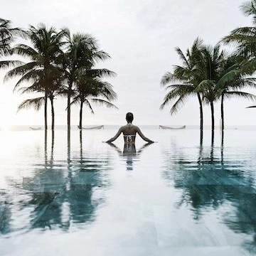 lady in pool with palm trees