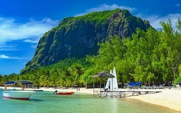 beach and sea with a boat and mountain